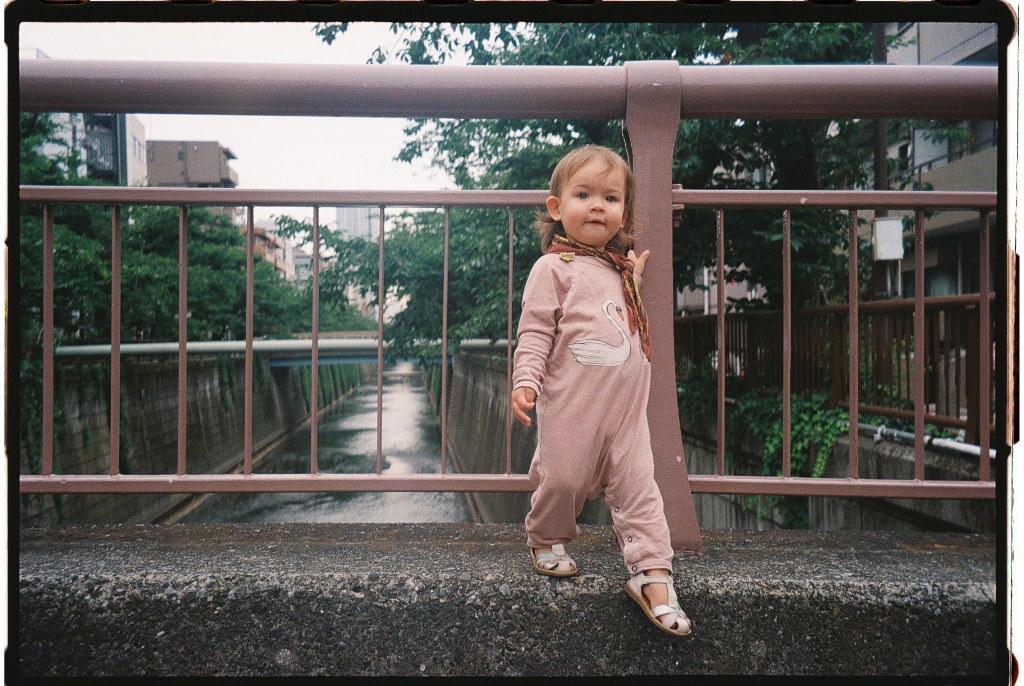 The best places to stay in Tokyo with kids: a toddler on a bridge crossing Nakameguro River 